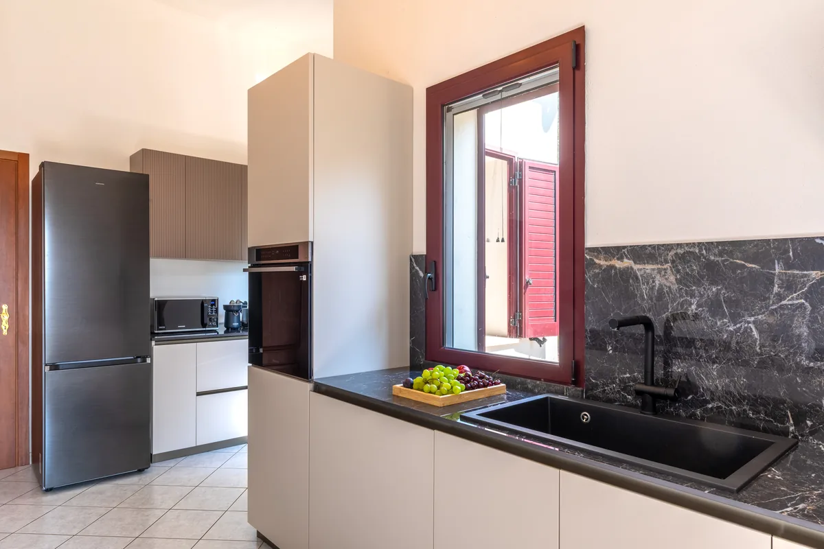 Cucina moderna con forno, frigorifero e piano in pietra nera