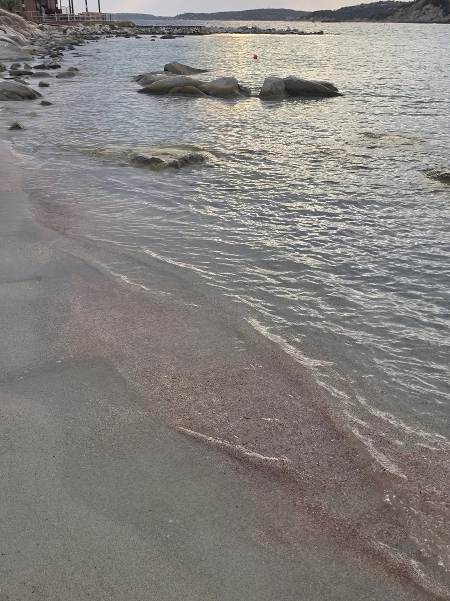 Rosafarbener Sand und klares Wasser