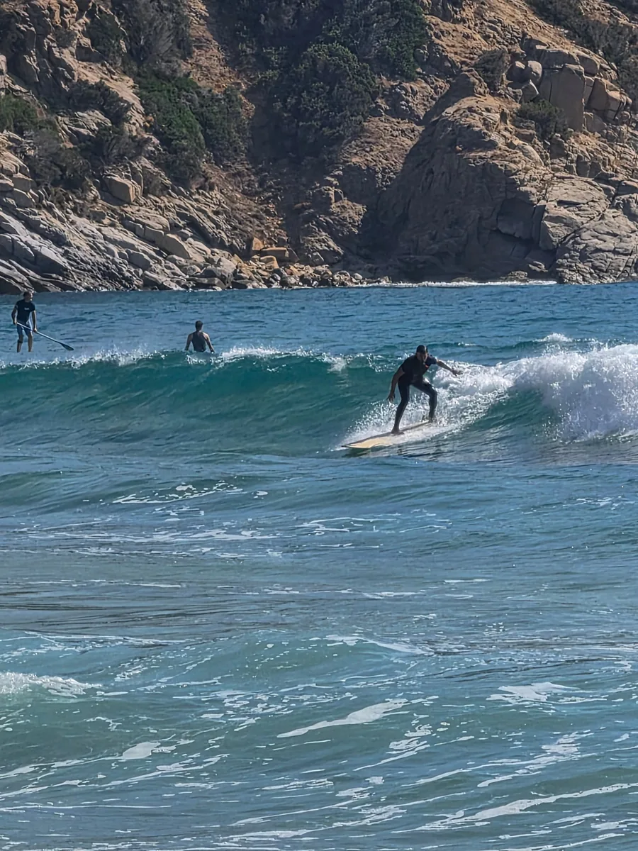 Surfen in den Wellen bei den Felsen